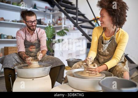 young Smiling creative artists making Handmade pottery in studio. Creative, hobby ,workshop  concept Stock Photo