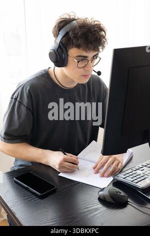 Teenager in Headphones Learning Mathematics Online at Computer Desk — Focused Student Studying at Home with Digital Tools, Remote Education and STEM Stock Photo