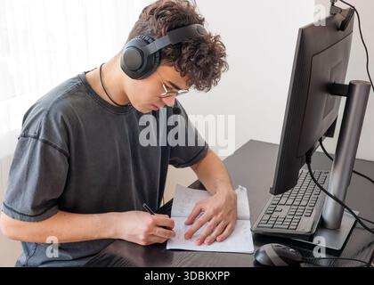 Teenager in Headphones Learning Mathematics Online at Computer Desk — Focused Student Studying at Home with Digital Tools, Remote Education and STEM Stock Photo