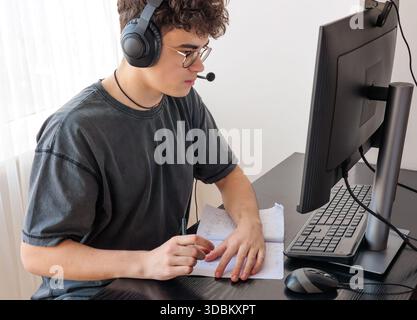 Teenager in Headphones Learning Mathematics Online at Computer Desk — Focused Student Studying at Home with Digital Tools, Remote Education and STEM Stock Photo