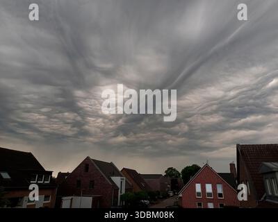 Dark storm clouds over houses Stock Photo