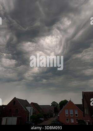 Dark storm clouds over houses Stock Photo