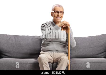 Elderly man sitting on a sofa and smiling isolated on white background Stock Photo