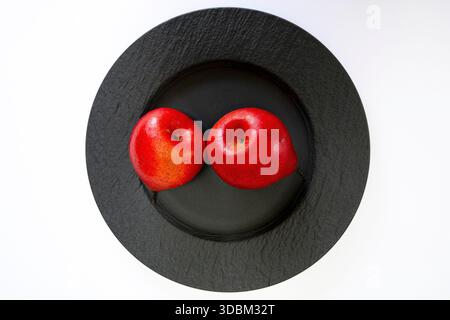 Two red pears on a black plate, a still life Stock Photo
