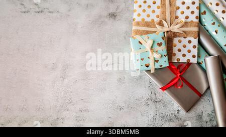 Gift boxes with festive wrapping and ribbon on the side. Ample negative space for text or design overlay. Cozy and elegant vibe Stock Photo