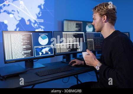 Cybersecurity analyst monitoring systems in a secure operations center Stock Photo