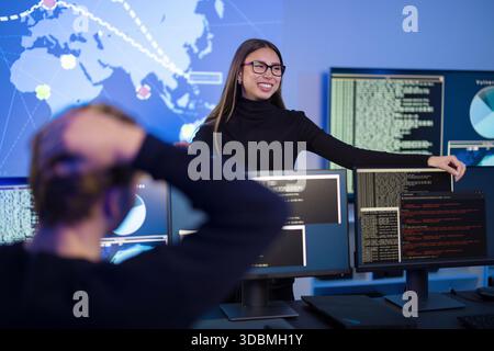 Team analyzing cybersecurity threats in modern security operations center Stock Photo