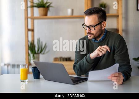 Success man typing on laptop, communicating online distantly working or studying on computer at home Stock Photo