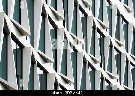 Hotel facade, Münster, Germany, a curved building front with triangular white frames and floor-to-ceiling windows, designed by KRESINGS architects, honeycomb like structure Stock Photo