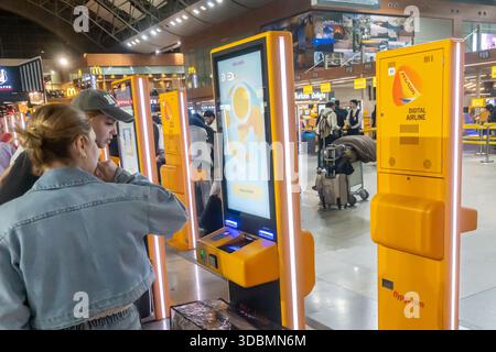Tourists use Pegasus Airlines self-service check-in kiosk located in an airport terminal, Istanbul Sabiha Gokcen Airport (SAW) hub Stock Photo