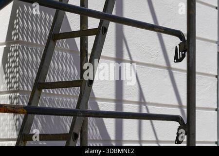 Aalen, Germany, shadows of scaffolding and ladder cast geometric patterns on the white facade of a house, creating an interplay of structure and light Stock Photo