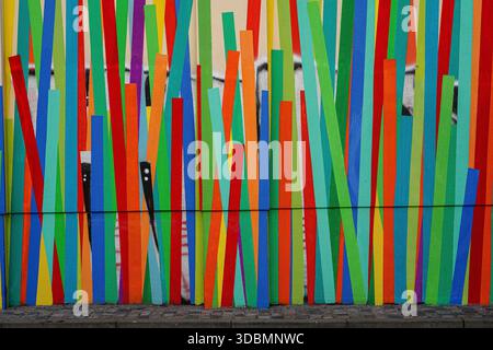 Dresden, Germany, colorful painted facade of a house wall with vertical striped pattern in red, blue, green, yellow, and orange tones. Stock Photo