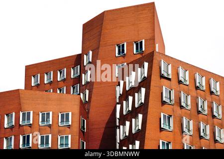 Düsseldorf, North Rhine-Westphalia, Germany, The Gehry Building at the Media Harbour, Neuer Zollhof House A, designed by architect Frank O. Gehry, features a facade completely covered with red clinker bricks and irregularly aligned windows Stock Photo
