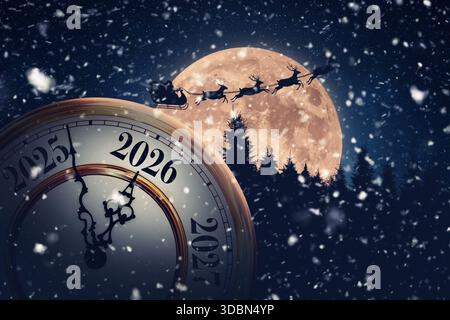 Magical Holiday Time Transition To 2026. A Snowy, New Year's Eve Clock Is Set Against A Massive Full Moon With Santa Claus And His Reindeer Flying Acr Stock Photo