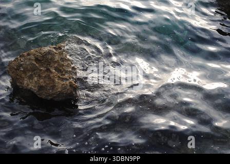 Shiny formations around a lonely stone on the water Stock Photo