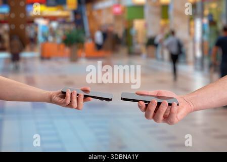 Wireless data exchange between two smartphones using close range communication, representing contact sharing, phone number transfer, digital identity, Stock Photo