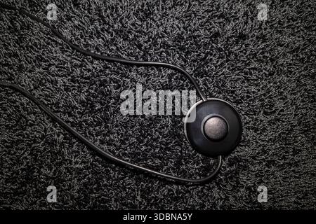 top view of a foot switch of a floor lamp on a long-pile carpet, all in black Stock Photo