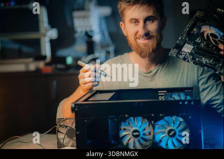 Man assembles a computer system unit at home Stock Photo