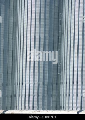 RHINE RIVER, GERMANY - MAY 26, 2025 - Metal silo exterior showing textured corrugated steel panels with strong vertical lines and a small ladder, repr Stock Photo