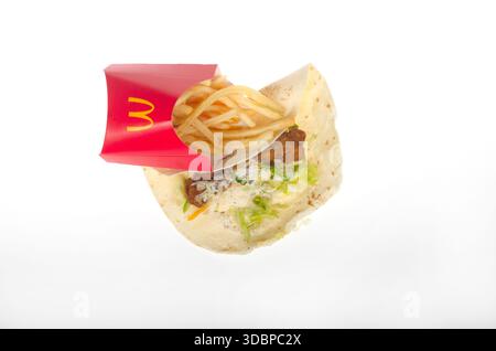 McDonald's snack wrap with large french fries unwrapped and isolated on white background. Stock Photo