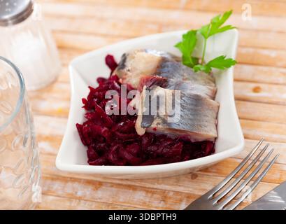 Sliced herring with grated beetroot served on table Stock Photo