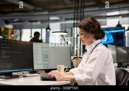 System administrator in Silicon Valley company office developing software apps. IT professional using computer at work to do coding, debugging applications to resolve issues Stock Photo