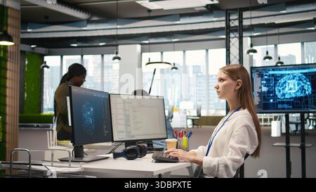 Female engineer using AI LLM chatbot, optimizing company systems performance. System administrator uses artificial intelligence assistant to convert manual workflows into automated scripts, camera A Stock Photo