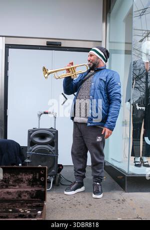 Edinburgh, UK - 31 OCT 2025 - A busker in the street playing a Trumpet to entertain passers by. Stock Photo