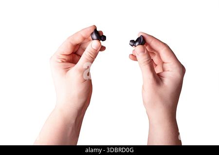 Modern technology black headphones pods in hand isolated on white background. Wireless headphones. A new way to reduce music. The concept of new techn Stock Photo