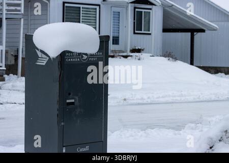 Canada, Quebec, 13 November 2025 : Thick snow on Canada Post mailbox outside suburban residential house Stock Photo