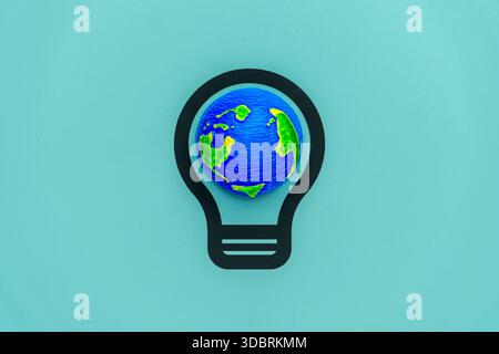 A miniature globe inside a light bulb icon. Earth Hour, global energy conservation, sustainable ideas, and environmental awareness concept. Copy space Stock Photo