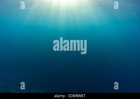 Sunrays streaming through the shallow water creating god rays in at the surface, Komoodo National Park, Flores Sea, Indonesia, Pacific Ocean Stock Photo