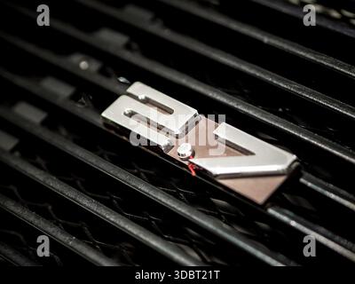Close-up of a Porsche 911 Carrera RS 2.7 badge mounted on the rear engine grille of a classic air-cooled sports car. Stock Photo