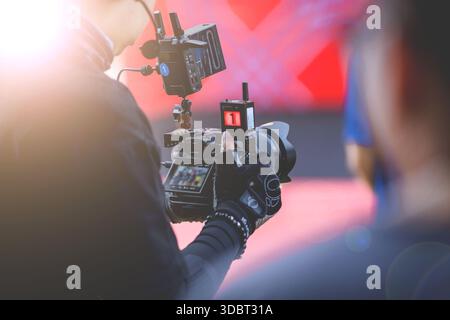 Video recording activities by on-stage photographers at sporting events.Professional videographer capturing the moment with high-end camera rig Stock Photo