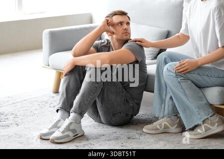 Young woman supporting man with suicidal thoughts at home Stock Photo