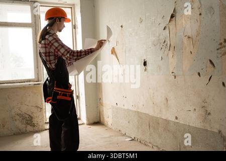 Repairman watching blueprint in apartment before repair. copy space Stock Photo