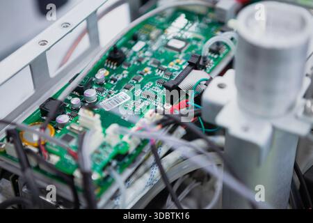 Inside of an electronic device with a green electronic circuit board. A green PCB with many electronic components such as IC, resistor, capacitor,... Stock Photo