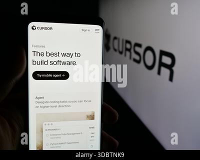 Stuttgart, Germany - 12-03-2025: Person holding cellphone with webpage of ai software company Cursor (Anysphere Inc.) on screen in front of logo. Stock Photo