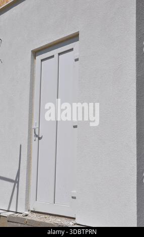 Closed White Back Door of Modern House on Stucco Exterior Wall Stock Photo