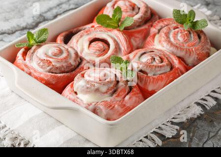 Festive pink cinnabon roll French buns with cinnamon and cream closeup on the plate on the table. horizontal Stock Photo