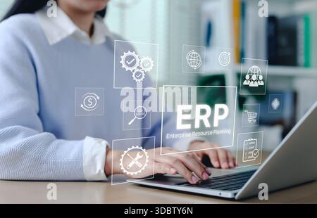 ERP Enterprise Resource Planning system concept. Businesswoman using laptop with interface ERP icons, business automation, data integration, workflow Stock Photo