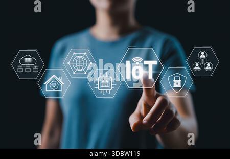 Internet of Things (IoT) technology concept. Woman touches glowing IoT interface with icons representing smart devices, connectivity, and various Stock Photo