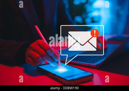 Email security threat notification and spam warning concept. Person using phone with warning and email symbol, cybersecurity threat, phishing attack, Stock Photo
