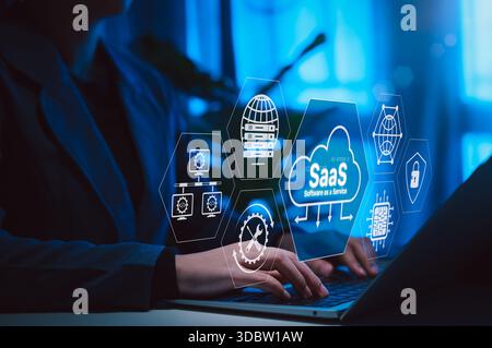 SaaS Software as a Service Cloud Computing Technology. Hands typing on laptop with SaaS icons, cloud systems, data servers, network elements, IT solut Stock Photo