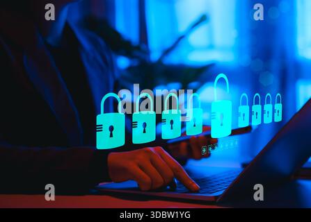 Cybersecurity Protection and Data Privacy Concept. Person using laptop with glowing padlock icons symbolizing security, data breach risk, privacy Stock Photo
