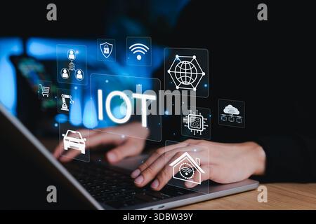 Internet of Things (IoT) Concept. Person using laptop with digital IoT icons representing smart technology, automation, wireless connection, data, AI, Stock Photo