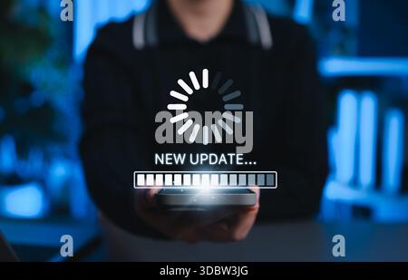 Mobile Software Update and Technology Upgrade Concept. Person holding smartphone with interface showing a loading progress bar and New Update message, Stock Photo