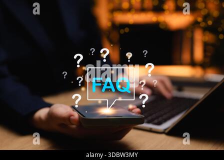 FAQ frequently asked questions concept. Woman holding smartphone with glowing FAQ icon above screen, symbolizing digital frequently asked questions Stock Photo