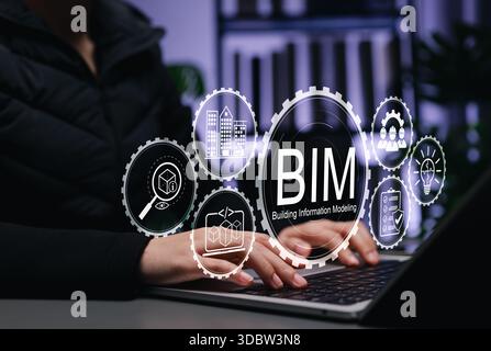 Engineer using laptop with BIM Icons representing Building Information Modeling technology for architecture, data, construction planning, 3D modeling, Stock Photo
