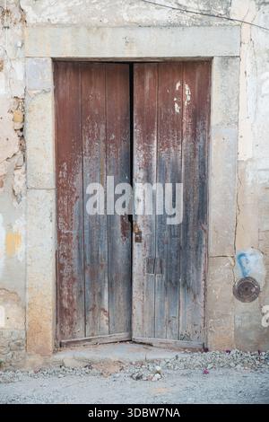 Old dilapidated double wooden doors in Tavira, Algarve, Portugal Stock Photo